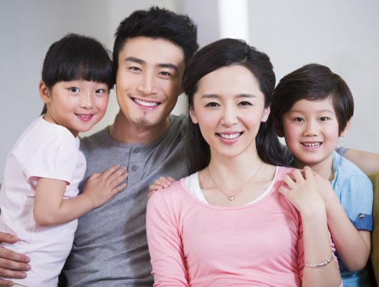 Happy Chinese family resting in sofa